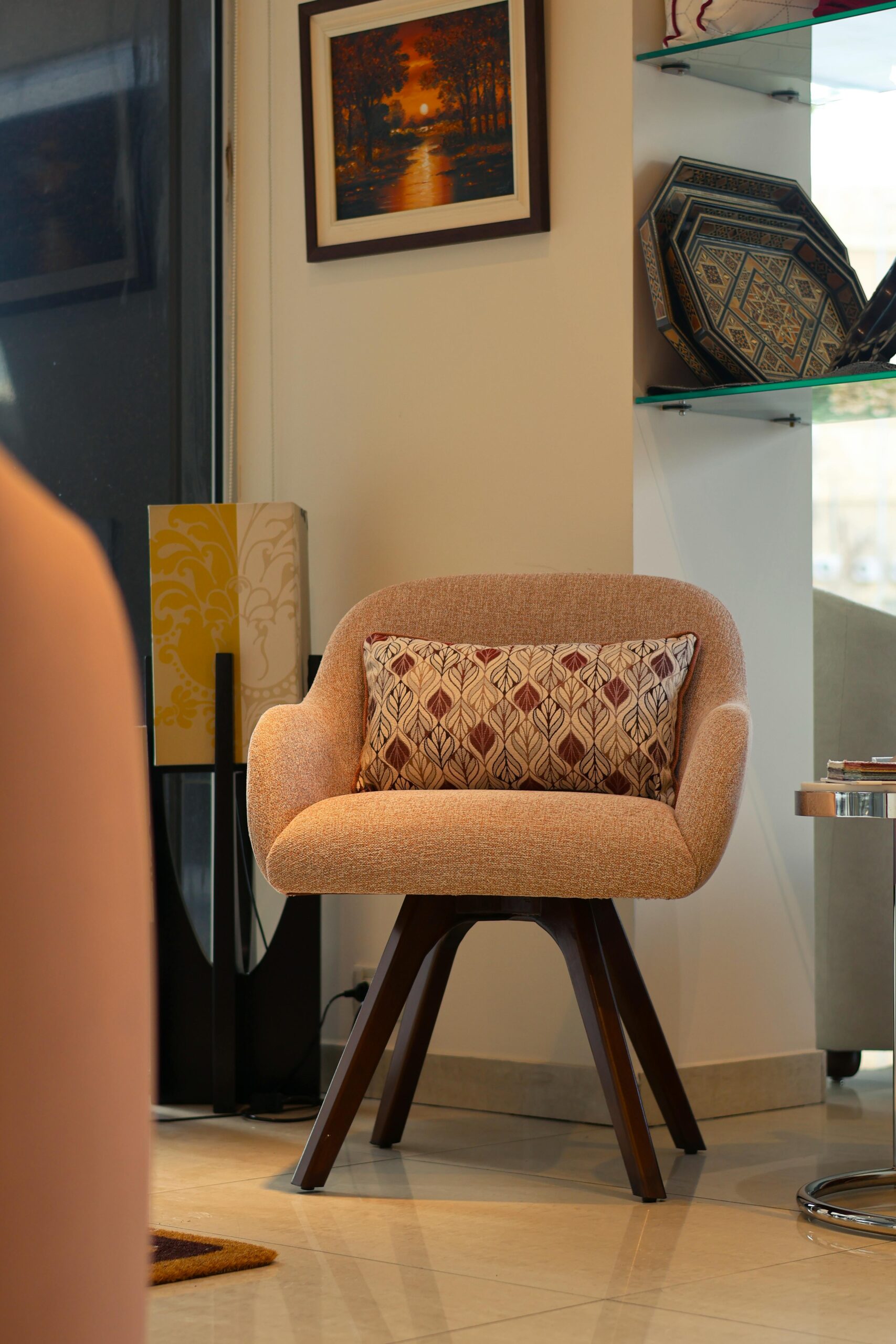 A stylish pink chair with cushion in a contemporary indoor living room.