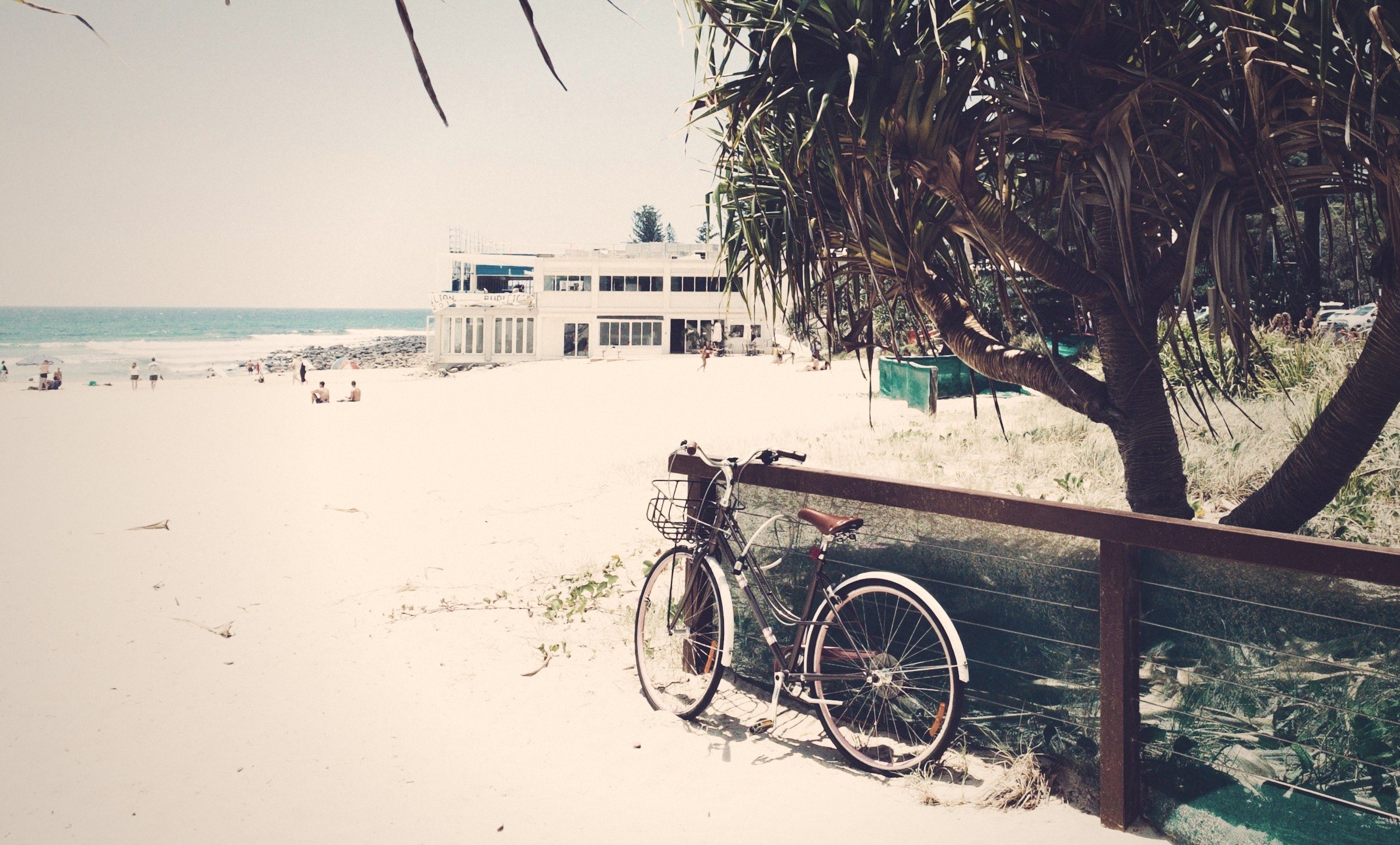 Bicycle parked by a wooden railing above the beach at Burleigh Heads